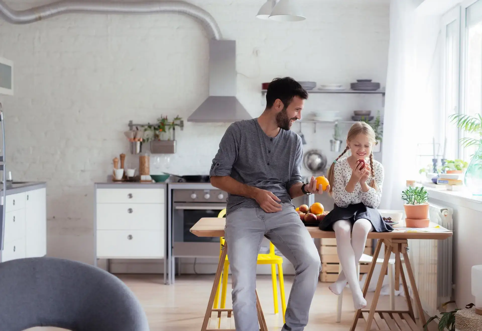 A father and daughter sitting on a kitchen island