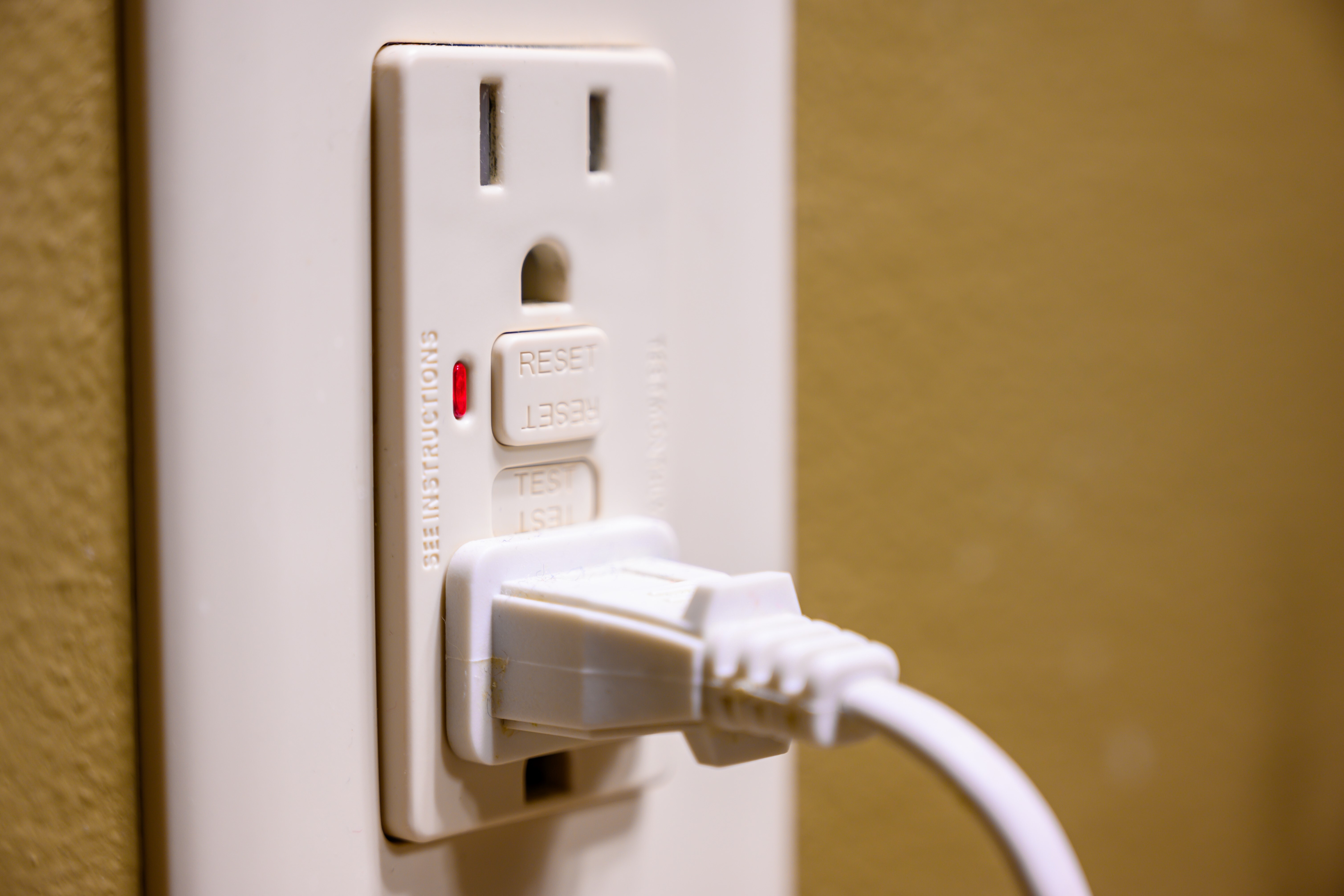A wall outlet that has its GFCI tripped with something plugged into it